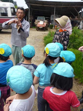 田植えの仕方を教える重博さん